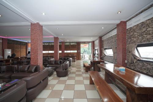 a restaurant with couches and tables and brick walls at Hotel Soreang in Bandung