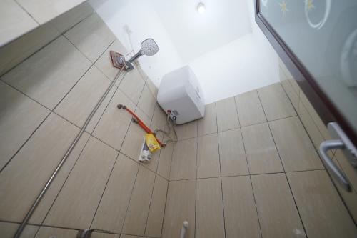 a bathroom with a broom and an umbrella on the floor at Hotel Soreang in Bandung