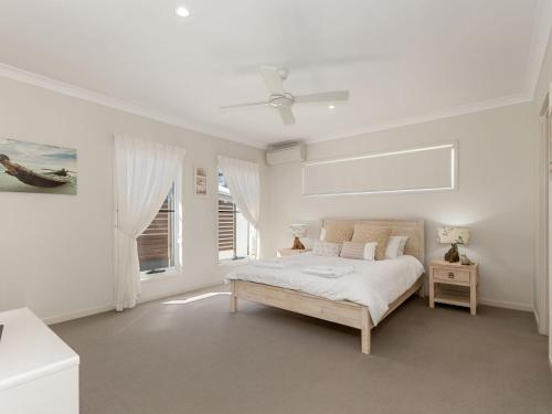 a white bedroom with a bed and a window at Salty Pause at Bondi House - Pet Friendly! in Kingscliff