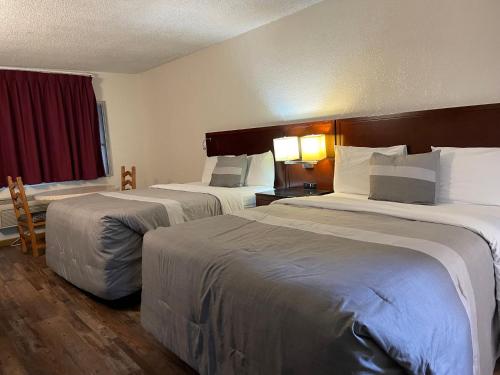 Habitación de hotel con 2 camas y ventana en Travelers Beach Inn, en Ventura