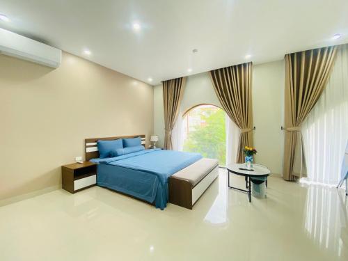 een slaapkamer met een blauw bed en een raam bij MetaHome SAKURA Apartment & Homestay -193 Văn Cao in Hai Phong