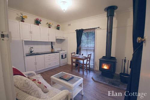 a kitchen with a stove in a living room at Tudor Cottages in Mount Dandenong