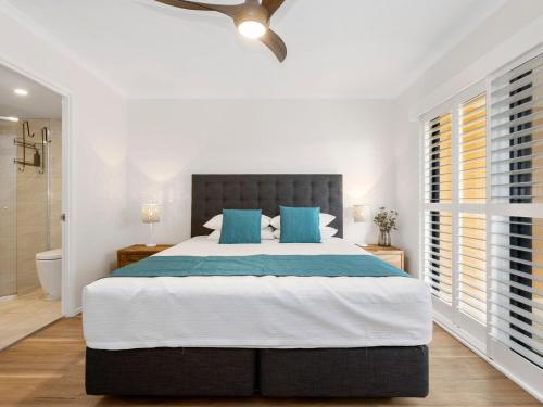 a bedroom with a large bed with blue pillows at Salty Kisses on Marine Parade in Kingscliff