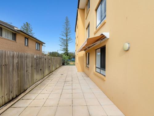an alley between two buildings with a fence at Salty Kisses on Marine Parade in Kingscliff