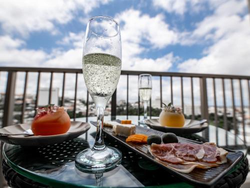una copa de champán sentada en una mesa con comida en Cozy Stay in Naha, en Naha