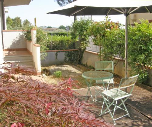 een patio met een tafel en stoelen en een parasol bij I Borghi in Empoli