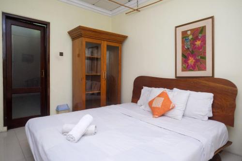 1 dormitorio con cama blanca y cabecero de madera en My Cafe Hotel near UGM Yogyakarta Mitra RedDoorz, en Kejayan