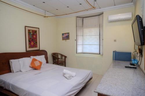 a bedroom with a bed and a television in it at My Cafe Hotel near UGM Yogyakarta Mitra RedDoorz in Kejayan
