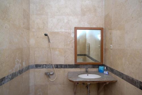 y baño con lavabo y espejo. en My Cafe Hotel near UGM Yogyakarta Mitra RedDoorz, en Kejayan