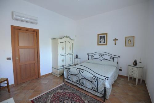 1 dormitorio con 1 cama y puerta de madera en Casavacanza Dattilo en Dattilo