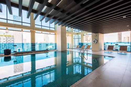 a swimming pool in a building with a view of the city at M Estate Private Residence 3BR, Heart of Bangkok in Bangkok