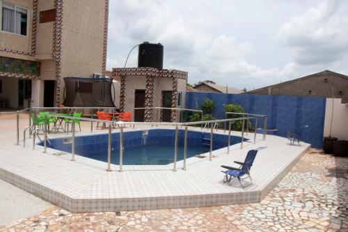 un patio con una piscina con una silla y una mesa en Alafia Hotel Ketou, en Kétou