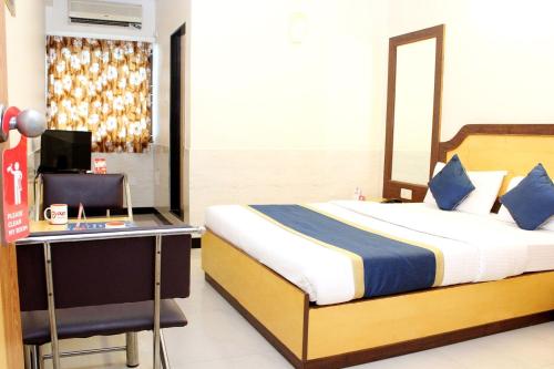 1 dormitorio con 1 cama y escritorio con ordenador en OYO Hotel Ganga Sagar Near Sri Someshwara Swami Temple, en Bangalore