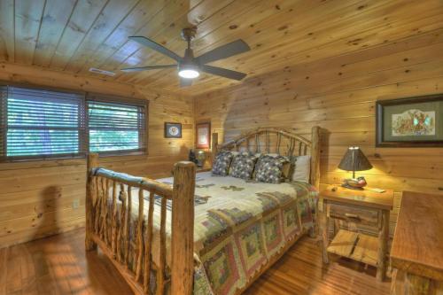 una camera con un letto in una baita di tronchi di Papa Bear Lodge a Blue Ridge