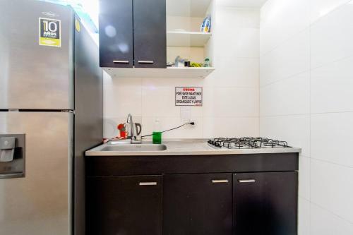 a kitchen with a sink and a refrigerator at EDIFICIO Niza80 ibague in Ibagué