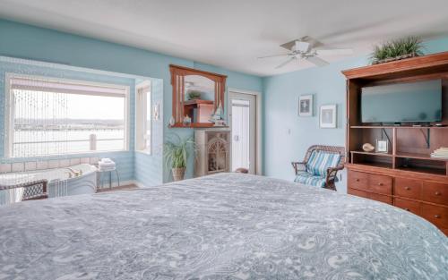 a bedroom with a large bed and a flat screen tv at Ocean's Edge - Anchor Pier Lodge in Newport