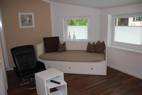 a small bedroom with a bed and a chair at Pension Kellerer in Raubling
