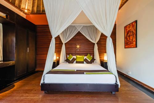 a bedroom with a bed with a canopy at Villa Sasoon, 100 mt to Beach in Candidasa