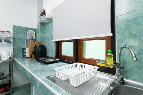 uma cozinha com um suporte para secar pratos no lavatório em Garden Home 1 em Haad Yao
