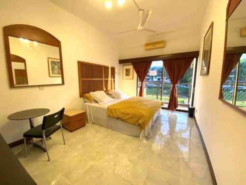 ポートディクソンにあるApartment by the Beach Port Dickson - Poolviewのベッドと机とテーブルのある寝室