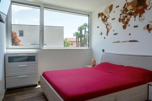 1 dormitorio con cama y ventana grande en [Free parking-Golf-Garden] en Losone