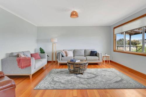 a living room with two couches and a rug at The BEST Scamander Beach House! in Scamander