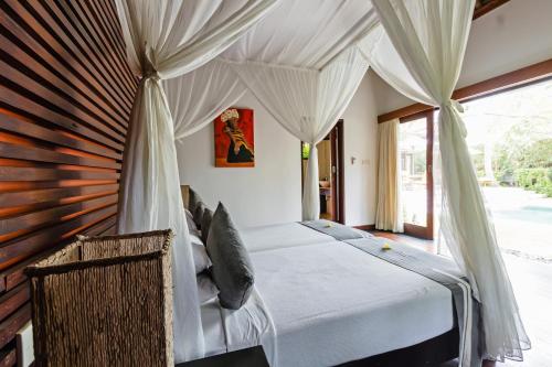 1 dormitorio con 1 cama con dosel en Villa Sasoon, 100 mt to Beach en Candidasa