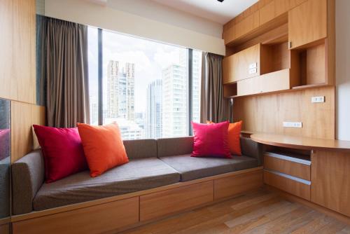 a bench with pillows on it in a room with a window at M Estate 2BR Private Residence, 300m to BTS Chit Lom in Bangkok