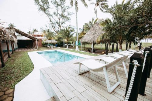 a swimming pool with lounge chairs next to a resort at Hotel Bungalows Marbella Costa Esmeralda in Monte Gordo