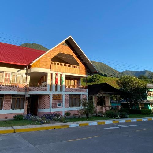 a building with flags on the side of a street at Schmidt Hostal in Pozuzo