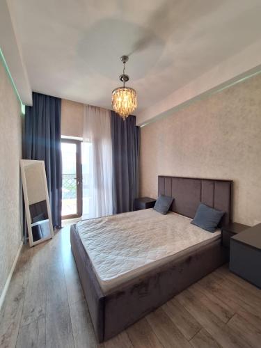 Un dormitorio con una cama grande y una lámpara de araña. en TZ en Baku