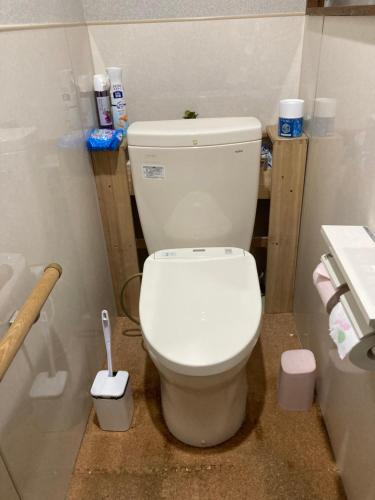 uma casa de banho com um WC branco numa cabina em オーベルジュ鳴門 em Naruto