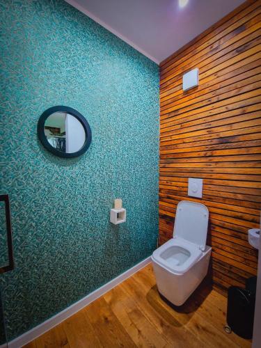 a bathroom with a toilet and a mirror on the wall at Bambuus Garden & Spa in Drăgăşani