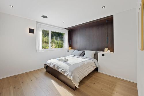 een slaapkamer met een groot bed en een raam bij The R Apartment Uetliberg, Klima, Parken - Wallbox in Geroldswil