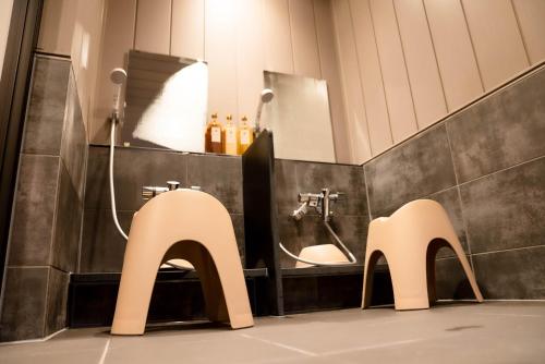 baño con lavabo y 2 sillas blancas en LOCOMOTION COFFEE AND BED, en Tateyama