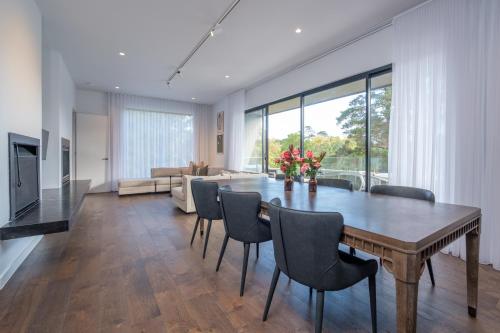 a living room with a wooden table and chairs at Hepburn Bathhouse & Spa Villas in Hepburn Springs
