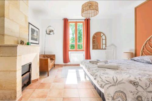 a bedroom with a large bed and a fireplace at La Roque de Bas in La Rivière