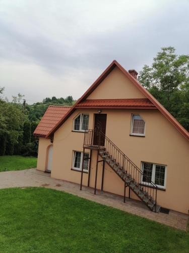 a house with a staircase in a yard at Całoroczny Domek Dwukondygnacyjny in Baligród