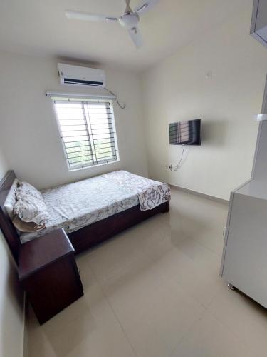 a small bedroom with a bed and a window at Blues Clue in Udupi