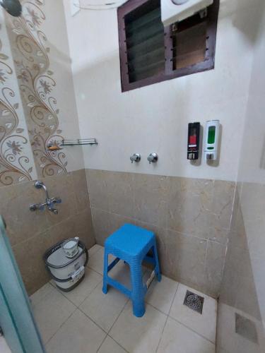baño con ducha y taburete azul en Kumars @udupi en Udupi