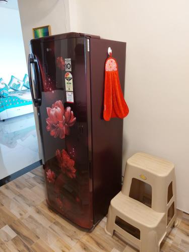a black refrigerator with flowers painted on the side of it at Blues Clue in Udupi