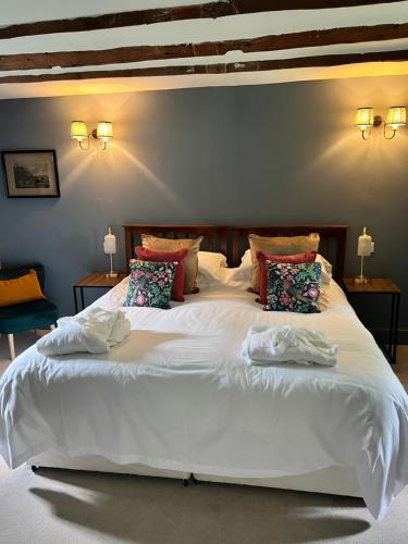 a bedroom with a large white bed with pillows at Blairbeg Cottage in Blairgowrie