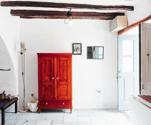 una camera con un armadio rosso e una parete bianca di JAJA Studios Paros a Paroikia