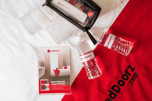 a bottle of water and a box on a bed at RedDoorz Syariah @ Jatiwangi Guest House 2 Cafe & Resto in Jatiwangi