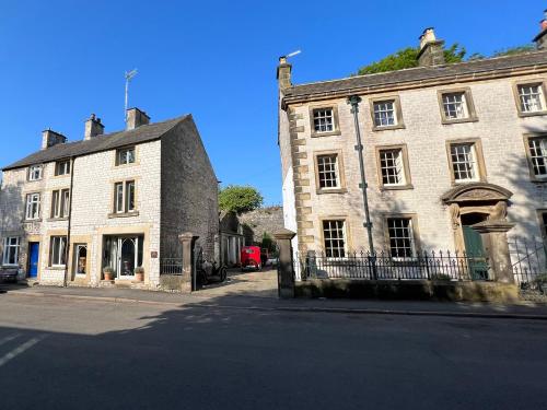 an old stone building on the side of a street at Billy Whiskey's in Tideswell