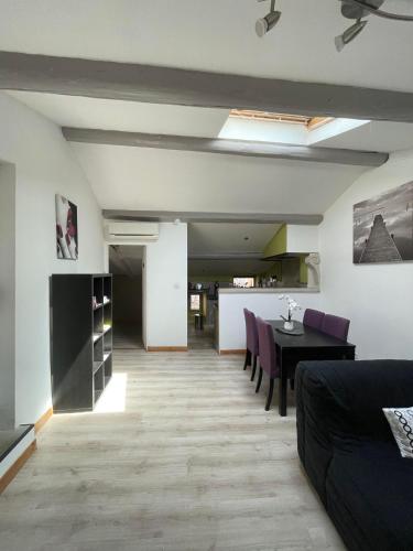 un salon avec une table et des chaises violettes dans l'établissement Appartement cosy plein de charme, à Saint-Rémy-de-Provence