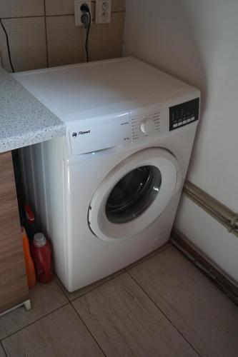 a white washing machine in a corner of a room at Chata Žár in Žár