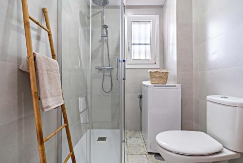 a bathroom with a toilet and a glass shower at Elegante Apartamento cerca al mar in Roquetas de Mar