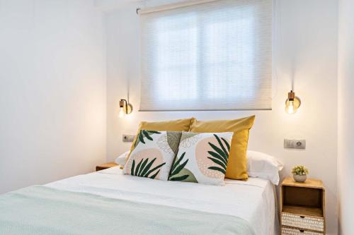 1 dormitorio con 1 cama con 2 almohadas y ventana en Elegante Apartamento cerca al mar en Roquetas de Mar