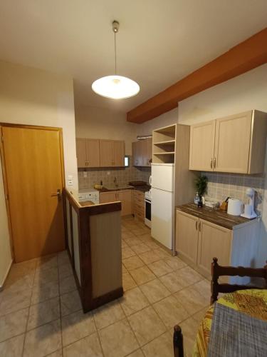 a large kitchen with a table and a door in it at pyrgospito in Éxo Nímfion